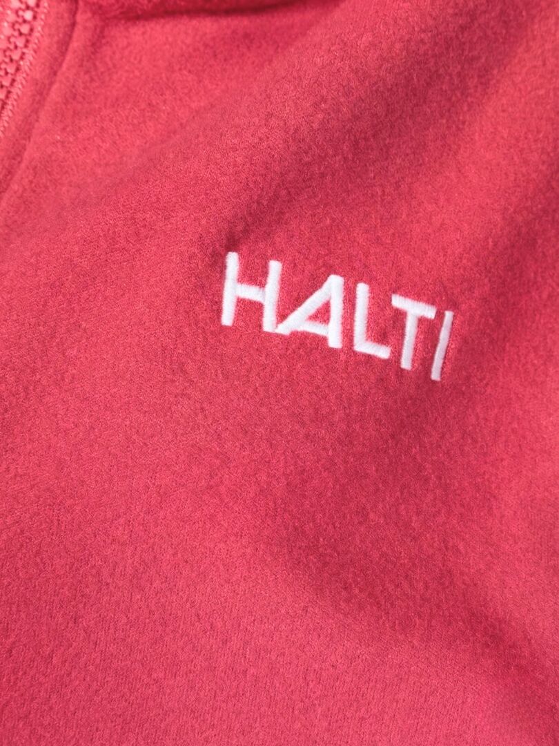 Närbild av en rosa Rockmoon Fleecejacka Dam by Halti med vit logotyp - en teknisk mellanlagerjacka för friluftsliv.