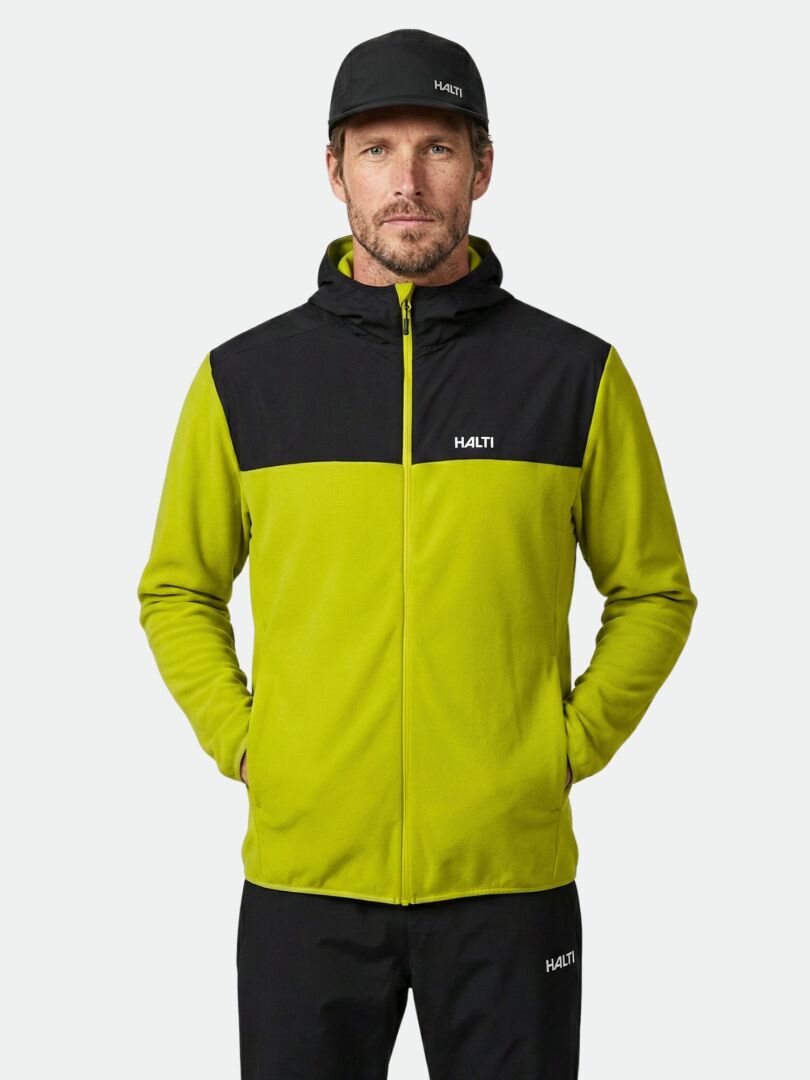 En man klädd i en Halti Rockmoon-fleecehoodie, svarta byxor och en svart keps – alla plagg bär stolt Halti-märket.