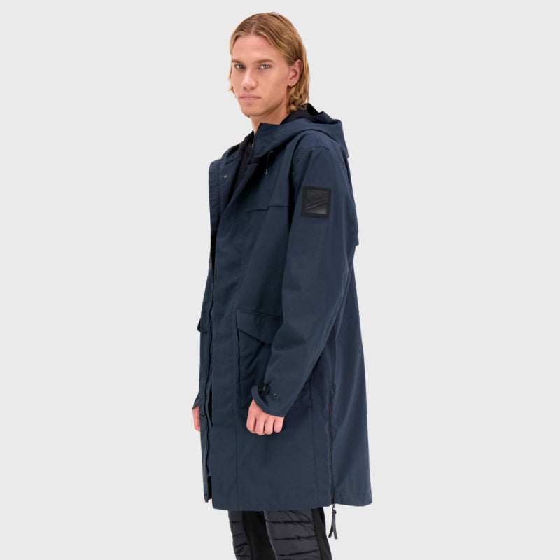 En person som bär en Halti Tokoi Herr DrymaxX Parka står mot en ljus bakgrund.
