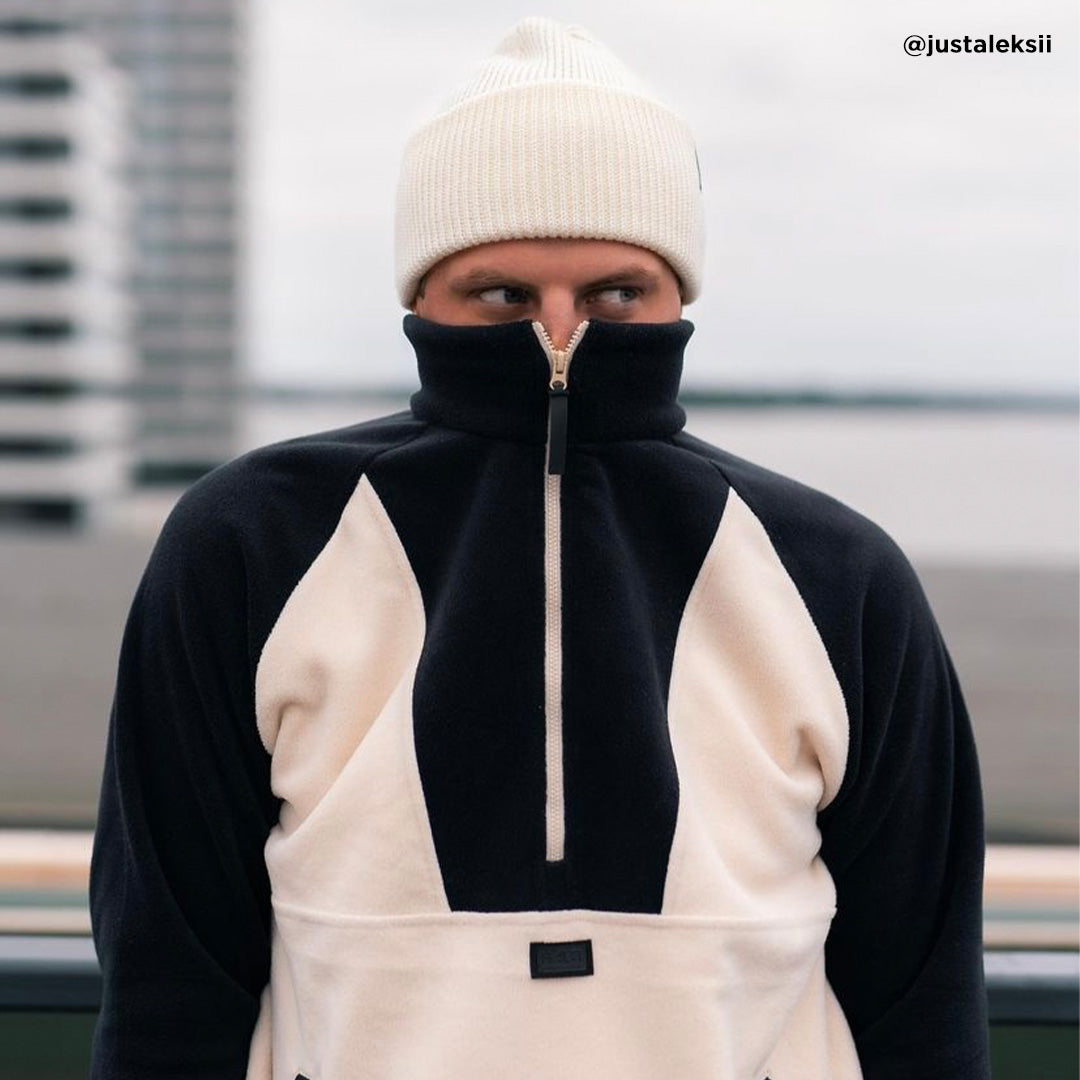 En person i en Halti Skugge Unisex fleece-anorak står utanför med dragkedjan upp till näsan och framhäver stilen.