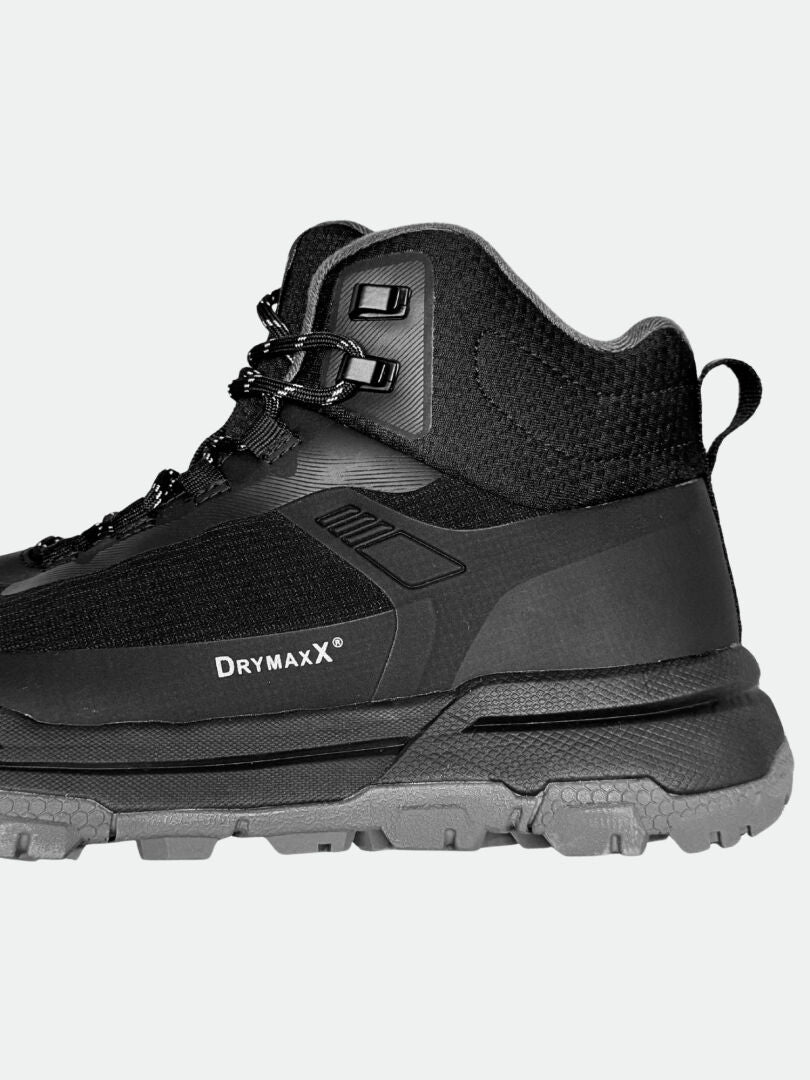 Sidovy på Halti Fara 3 DX Mid herr outdoorskor, svart med Drymaxx och robust grå sula för friluftsliv.