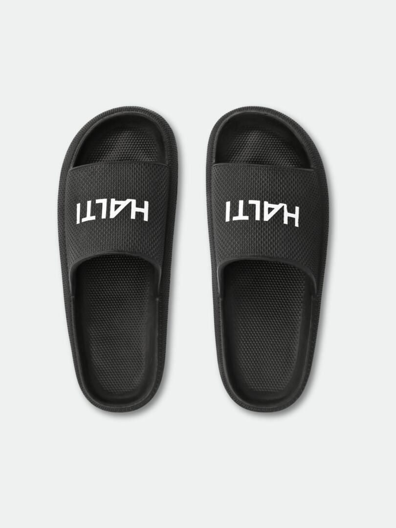 Eazy 2 Sandal från Halti - svarta EVA-sandaler med vitt logotryck, perfekta för dusch eller fritid.