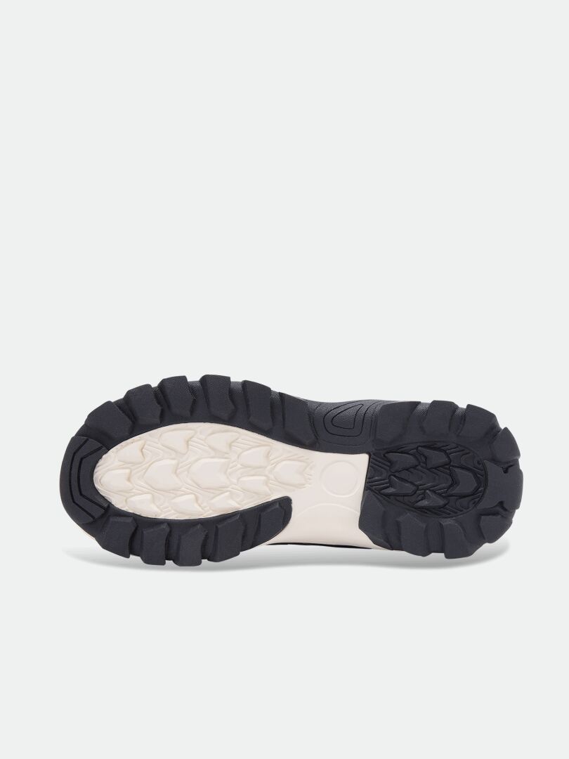 Svart och vit yttersula i gummi med klackar till skor av modellen Halti Tribe Dada DX Outdoor Skor Junior.