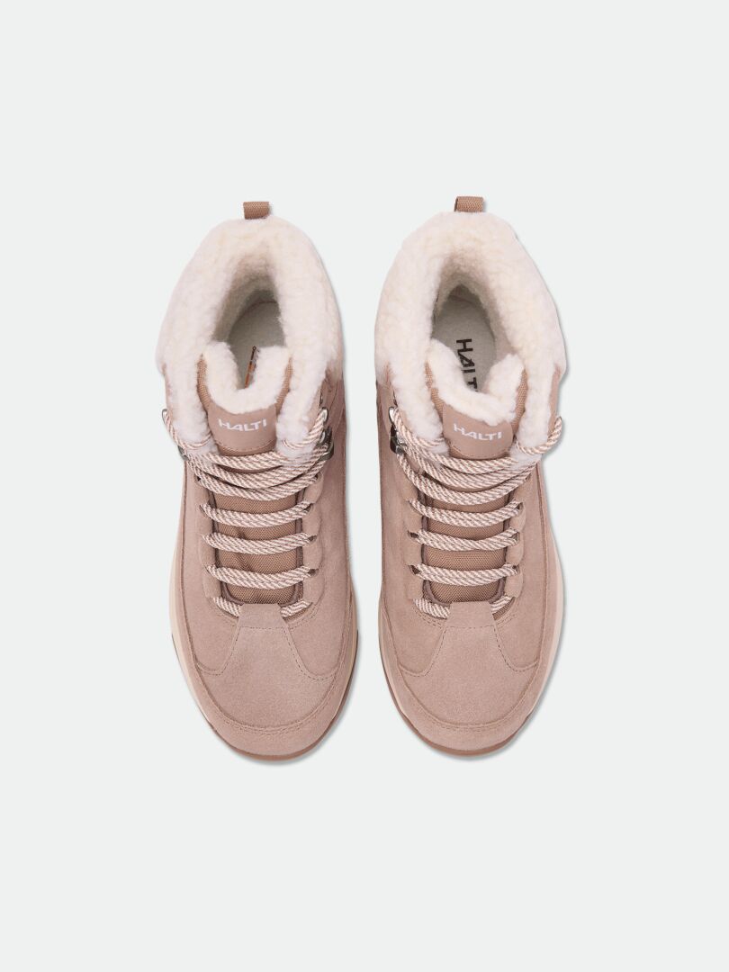 Halti Doris DX Vinterskor Dam – beige mockaankelstövlar med krämfärgat fleecefoder, sett uppifrån mot vit bakgrund.