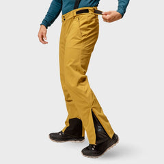 Person i Halti Trusty DrymaxX Skidbyxor Herr och svarta stövlar justerar midjebandet; ansiktet syns inte.