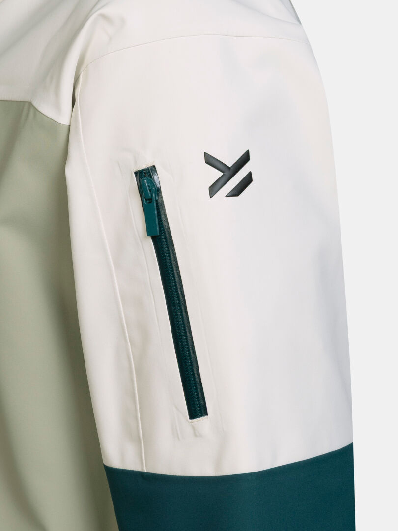Närbild på en vit och grön ärm från Rizle Unisex 3L DX Skidjacka med en ficka med dragkedja och en logotyp.