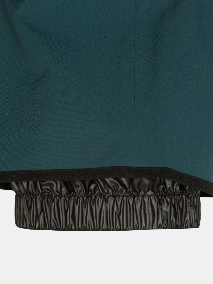 Mörkgröna Rizle 3L DX Skidbyxor (unisex) med en inbyggd svart snölist med resår i nederkanten.
