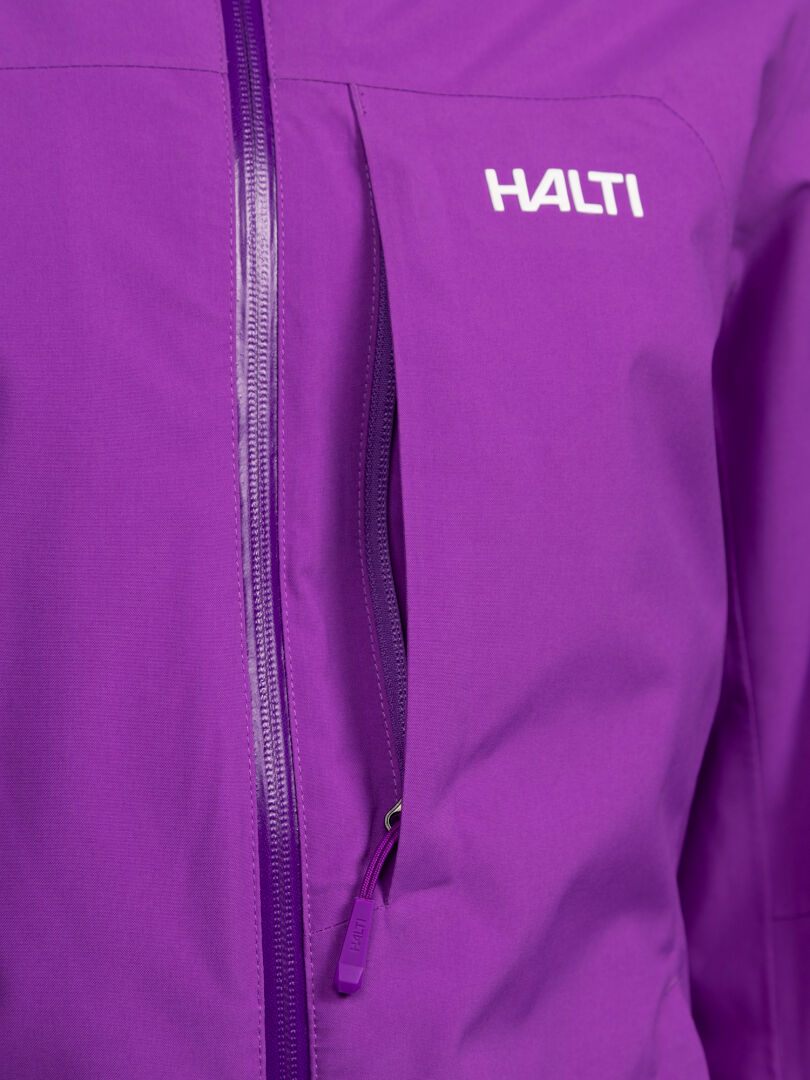 Närbild på en lila, vadderad Halti Melvik DX Skidjacka Dam med en bröstficka med dragkedja och en vit logotyp.