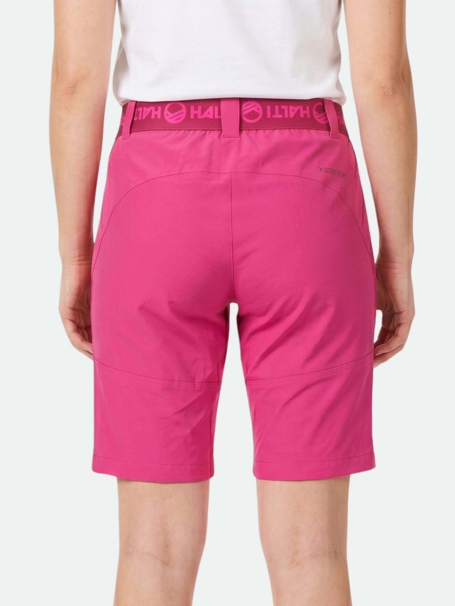 Person iklädd ljusrosa Halti Pallas Dam X-stretch Lite Shorts, fotograferad bakifrån på en vit bakgrund.