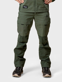 Person i Halti Hiker DrymaxX 3L Ventilated Byxor Herr och svarta vandringsskor, stående med händerna på höfterna.