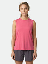 En person bär Halti Kalteva Top Dam i rosa med mörka shorts, stående mot en ljus bakgrund.