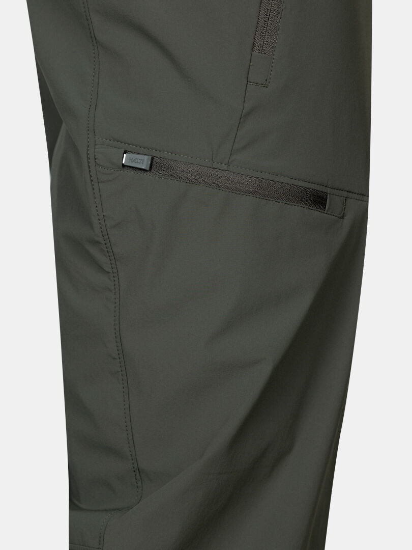 Närbild av en mörkgrön Pallas Cool X-stretch capribyxa från Halti, med dragkedjeficka och sömmar.