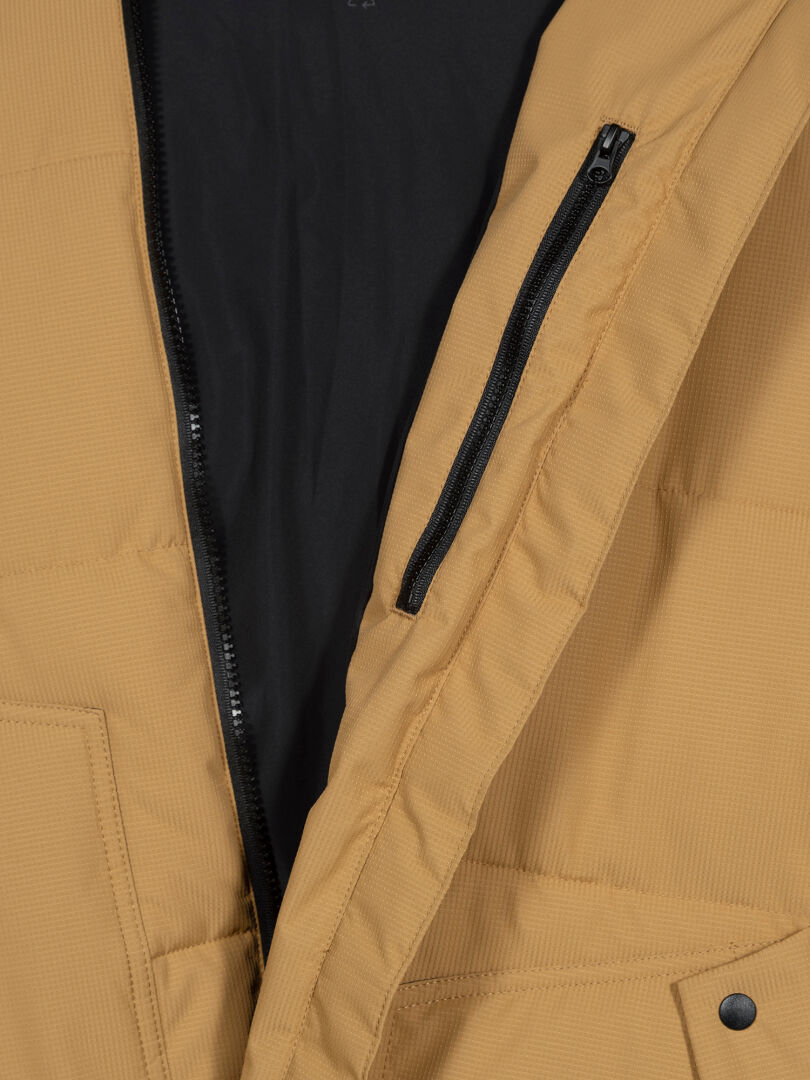 Närbild av den solbruna Halti Linjat Parka Jacka Herr, med svart dragkedja, bröstficka och svart innerfoder.