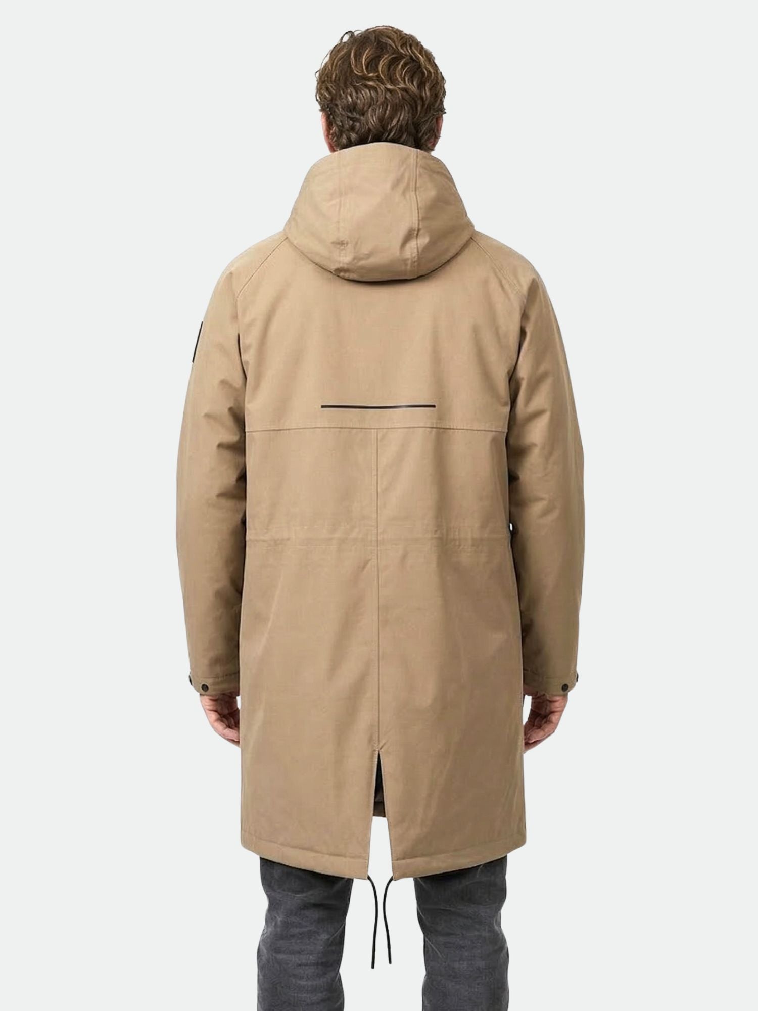 En mörkklädd person i Halti Flemari DX Parka Jacka Unisex står med ryggen mot kameran mot en vit bakgrund.