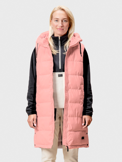 En person bär Halti Penger Puffer Väst Dam över en svartvit outfit och står mot en enfärgad bakgrund.