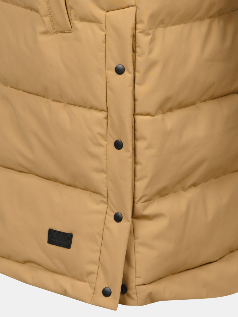 Närbild på Haltis Penger Puffer Väst Dam i beige med svarta tryckknappar, sömmar och en del av en svart etikett.
