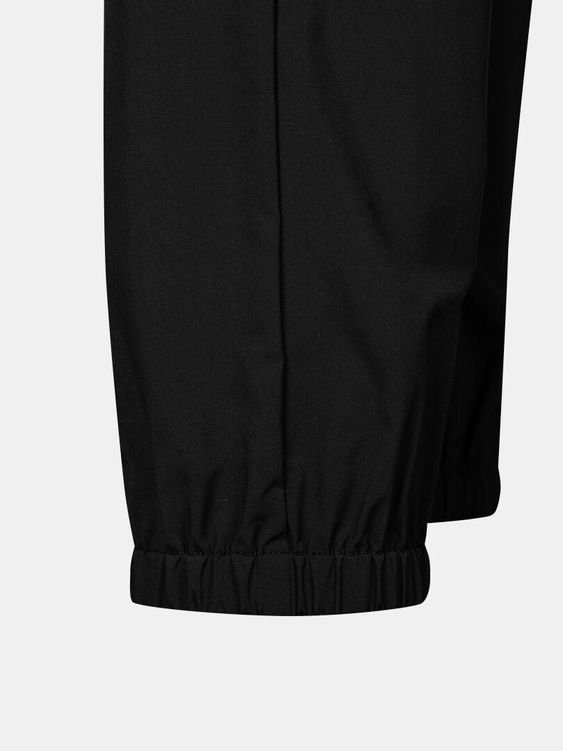 Närbild av Halti Grets Joggers Dam i svart med elastiska muddar och Quick Dry Lite Stretch-tyg mot en ljus bakgrund.
