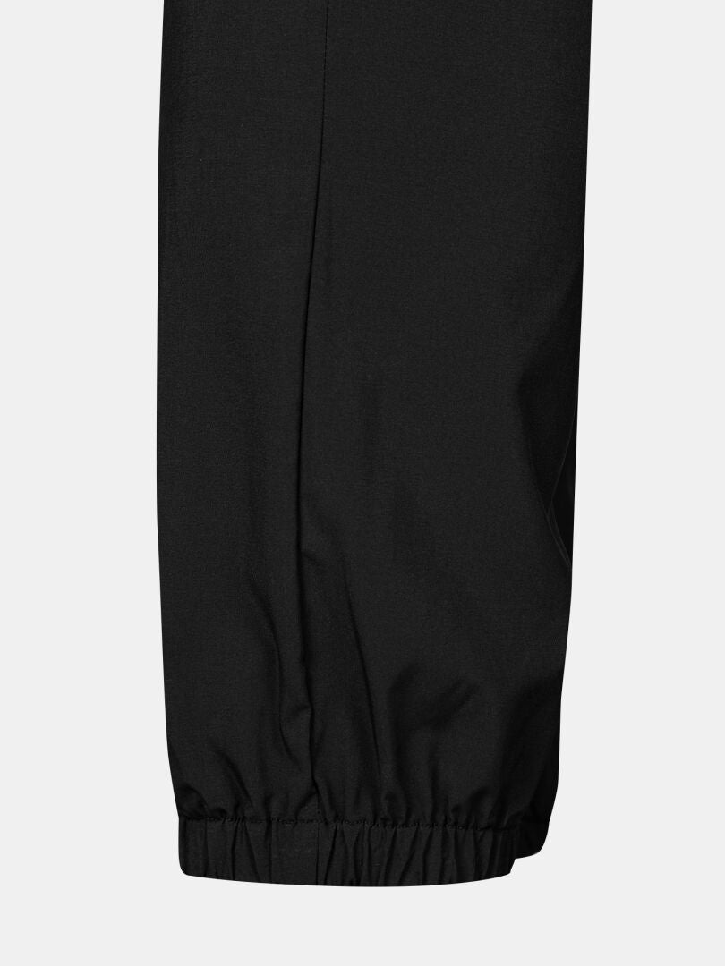 Närbild av Halti Grets Joggers Herr, svart med elastisk fotledsmanschett, mot en ljus bakgrund.