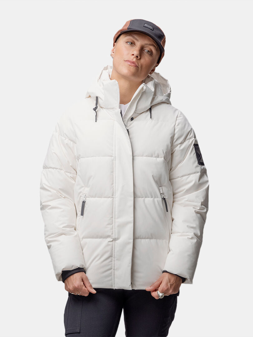 En person bär en Halti Brahe Puffer Vinterjacka Dam i återvunnen polyester mot en vit bakgrund.