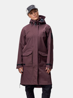 En kvinna bär Halti Tokoi II DX Parkajacka Dam, rödbrun, tillverkad av återvunnen polyester, mot en vit bakgrund.