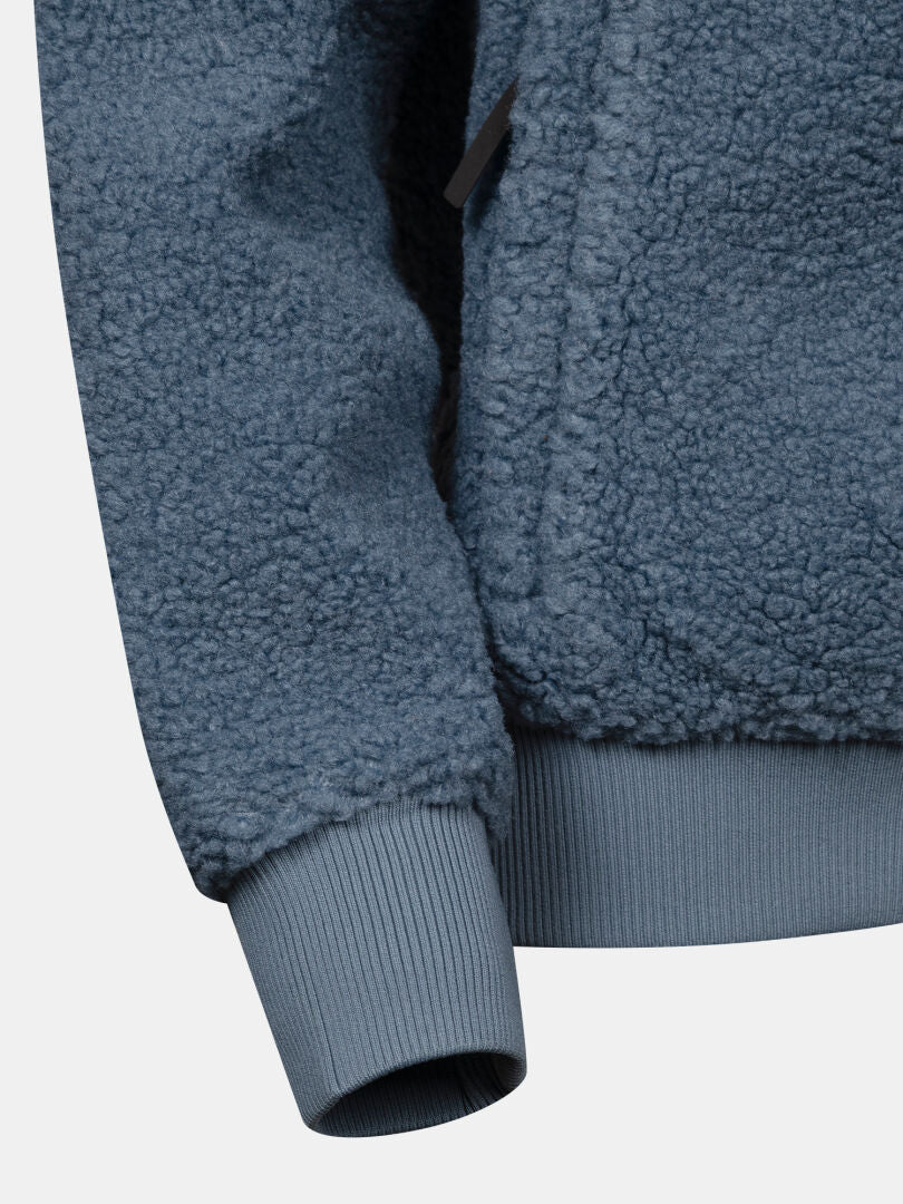 Närbild på ärmen på Halti Lykky Fleece Jacka Dam med ribbad manschett, som visar dess mjuka struktur och detaljerade sömmar.