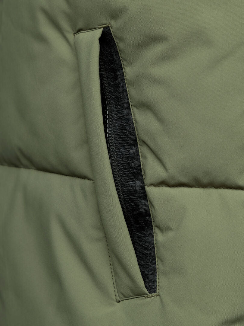 Närbild av Halti Penger Classic Puffer Väst Herr i olivgrönt, med dragkedja i svart sidoficka.