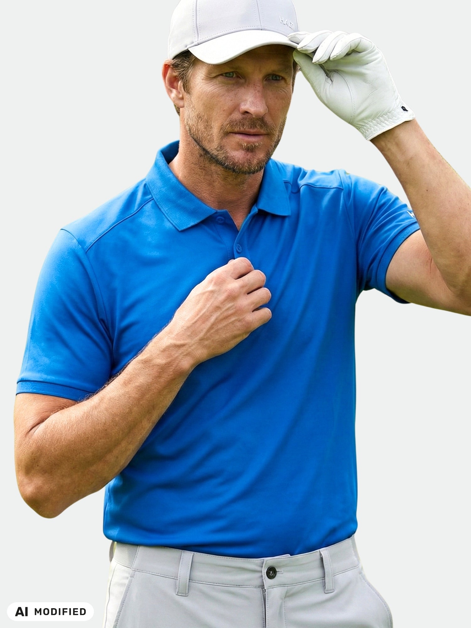 En man i en Aridi Teknisk Pikétröja från Halti rättar till sin vita golfmössa och bär en vit golfhandske på golfbanan.