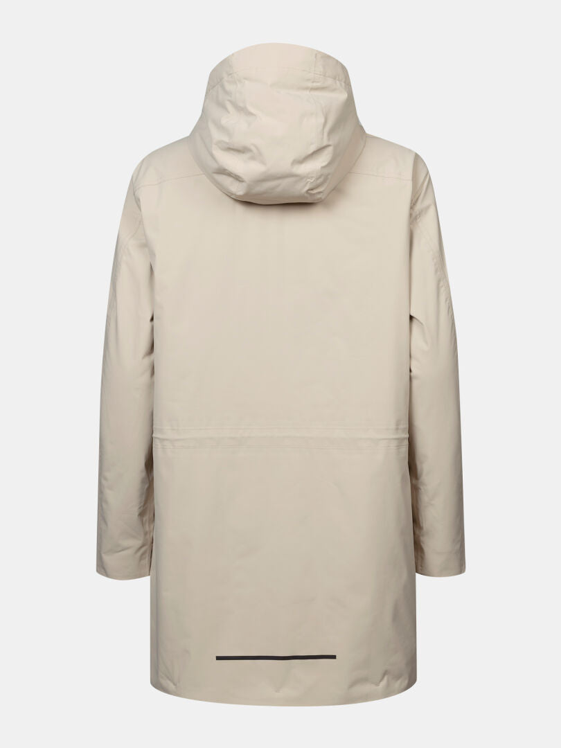 Halti Kortteli DX isolerad parkas för dam i beige med huva, raka ärmar och fåll, avbildad bakifrån mot vit bakgrund.