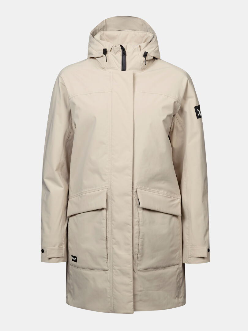 Halti Kortteli DX Dam: Beige, isolerad parka med dragkedja fram, fickor och svart logotyp på vänster ärm.