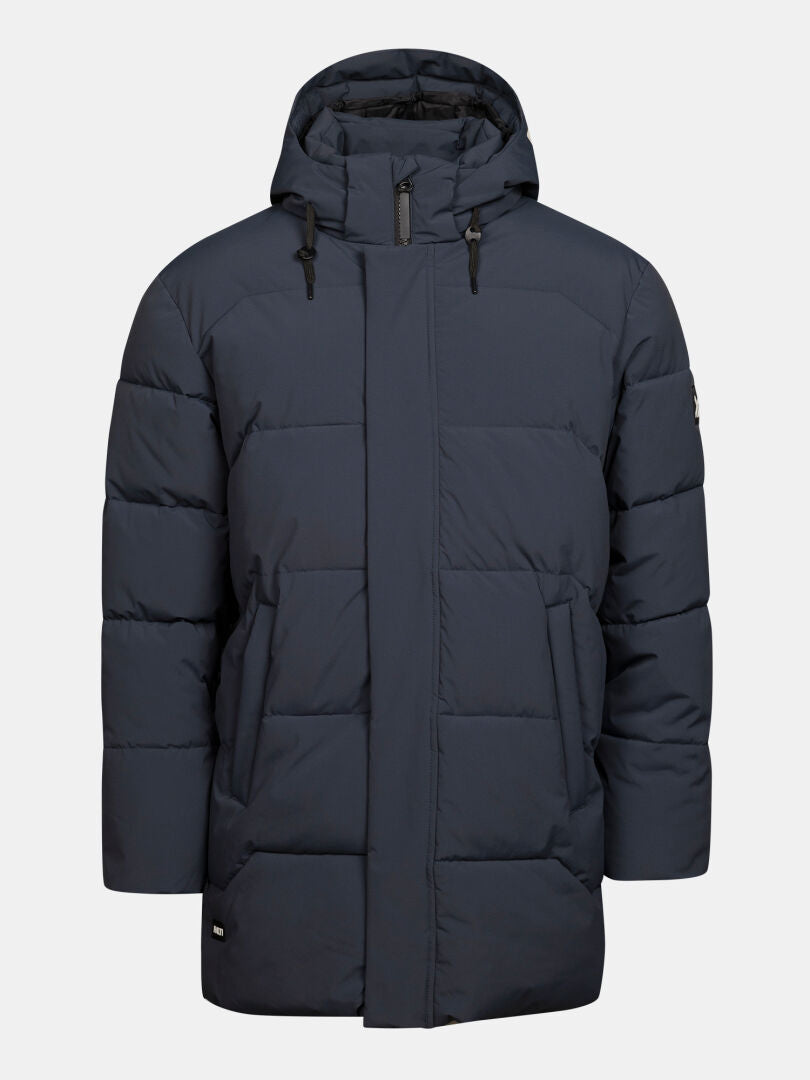 Halti Brahe Puffer Parka Herr i marinblått med huva, dragkedja fram, tryckknappar och två sidfickor mot enfärgad bakgrund.