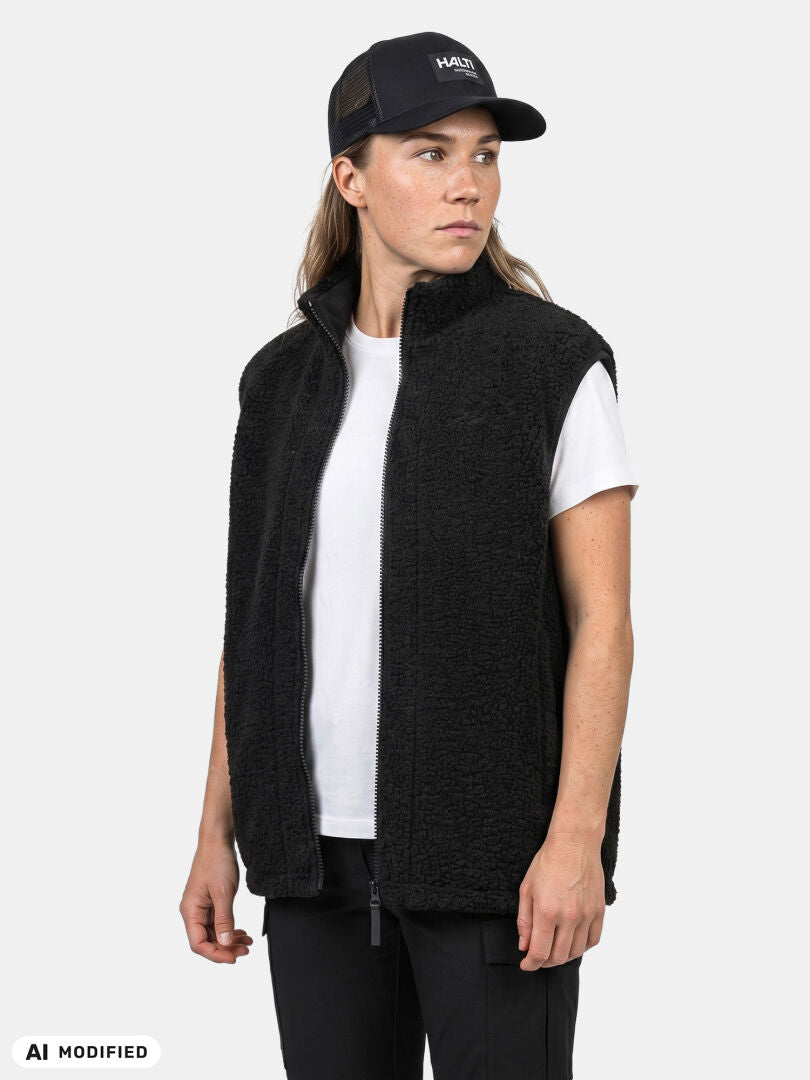 Halti Lykky Fleece-väst (unisex) i återvunnen polyester, svart keps, byxor och vit t-shirt mot en enkel bakgrund.