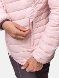 En person öppnar sidofickan på en ljusrosa Halti Huippu Mid Dunjacka Dam när han har mörka byxor på sig.