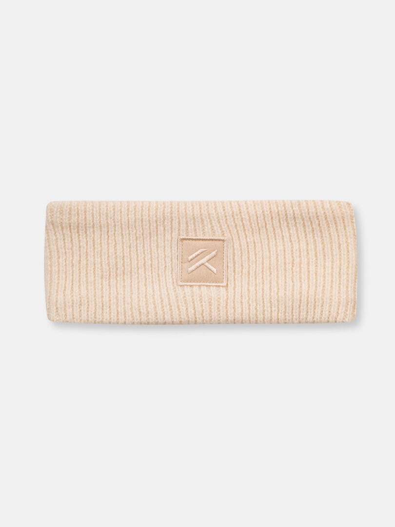 Halti Huurre Pannband är ett beige ribbstickat pannband med en fyrkantig patch och ett enkelt broderi i mitten.
