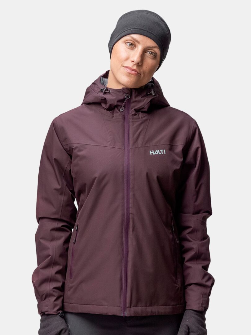 En person bär ett Halti Trone Fleece Pannband och en mörklila jacka med huva mot en ljus bakgrund.