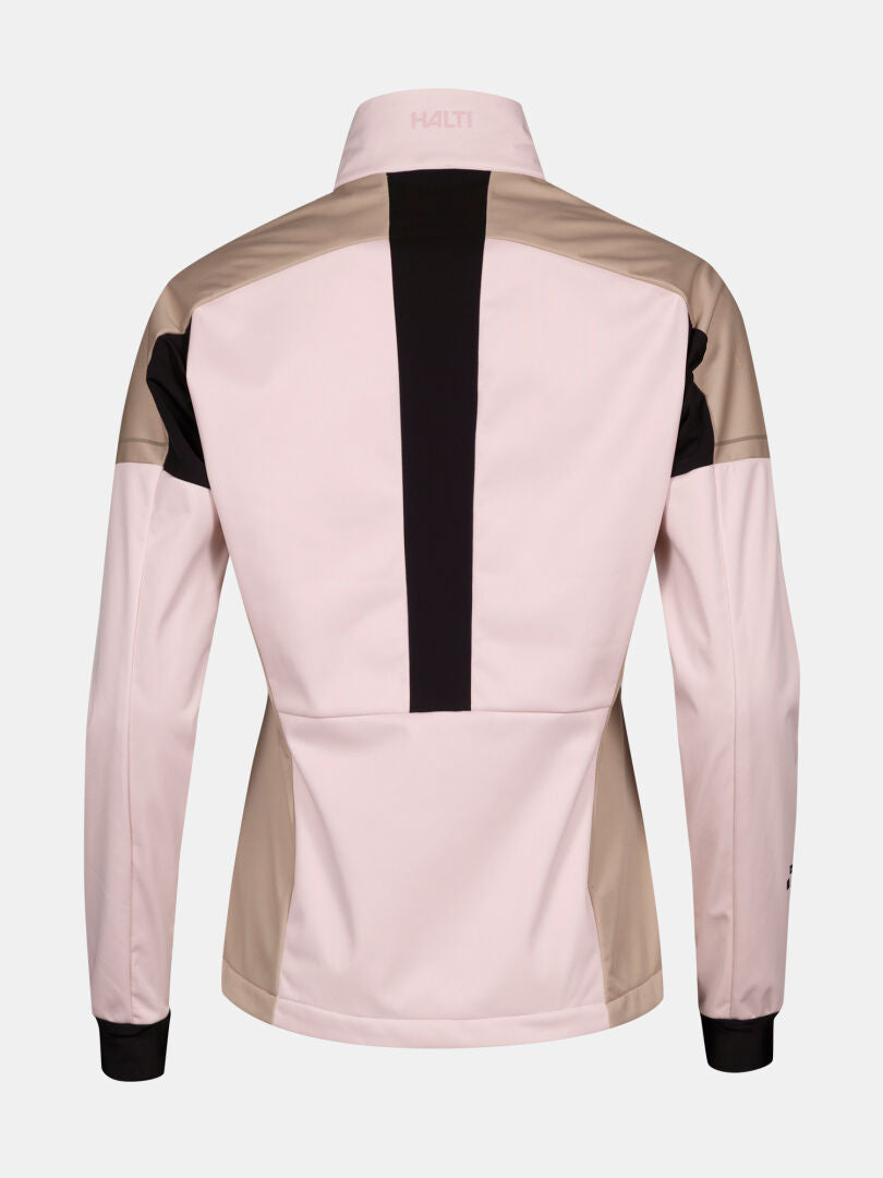 Halti Huuru Längdskiddräkt Dam är en ljusrosa/beige softshelljacka med svarta detaljer, perfekt för vinterträning.