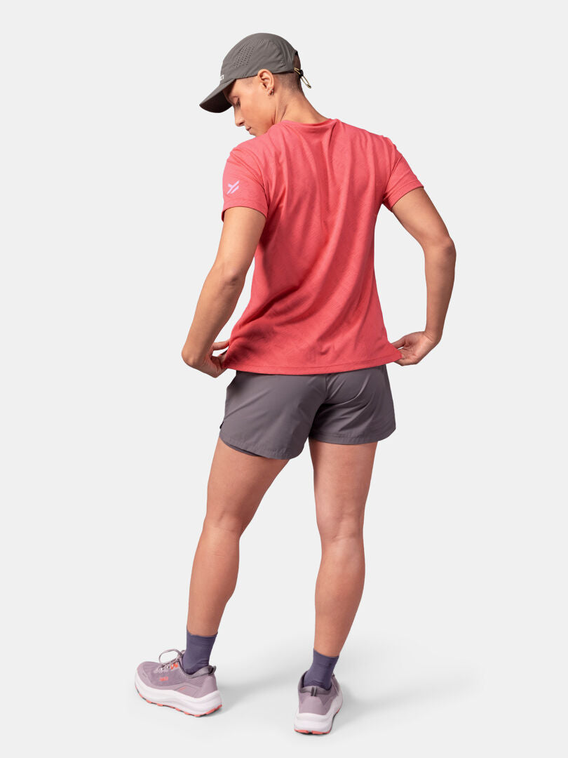 Person med ryggen mot kameran i Halti Oulanka T-skjorta Dam, grå keps, grå shorts och ljusa sneakers.