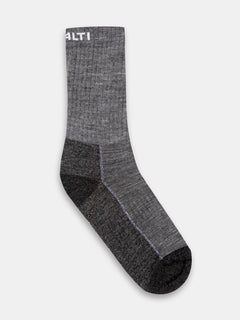 En enkel grå och svart Halti Trekking Warm Merinostrumpor-strumpa med ribbad textur och en vit logotyp nära toppen.
