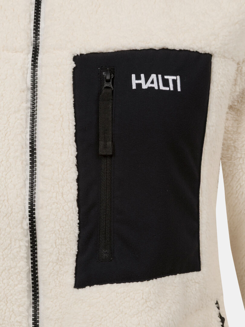 Närbild på Lumista Polar Fleecejacka Dam by Halti, cremefärgad fleece med svart bröstficka med dragkedja och vit logotyp.