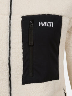 Närbild på Lumista Polar Fleecejacka Dam by Halti, cremefärgad fleece med svart bröstficka med dragkedja och vit logotyp.