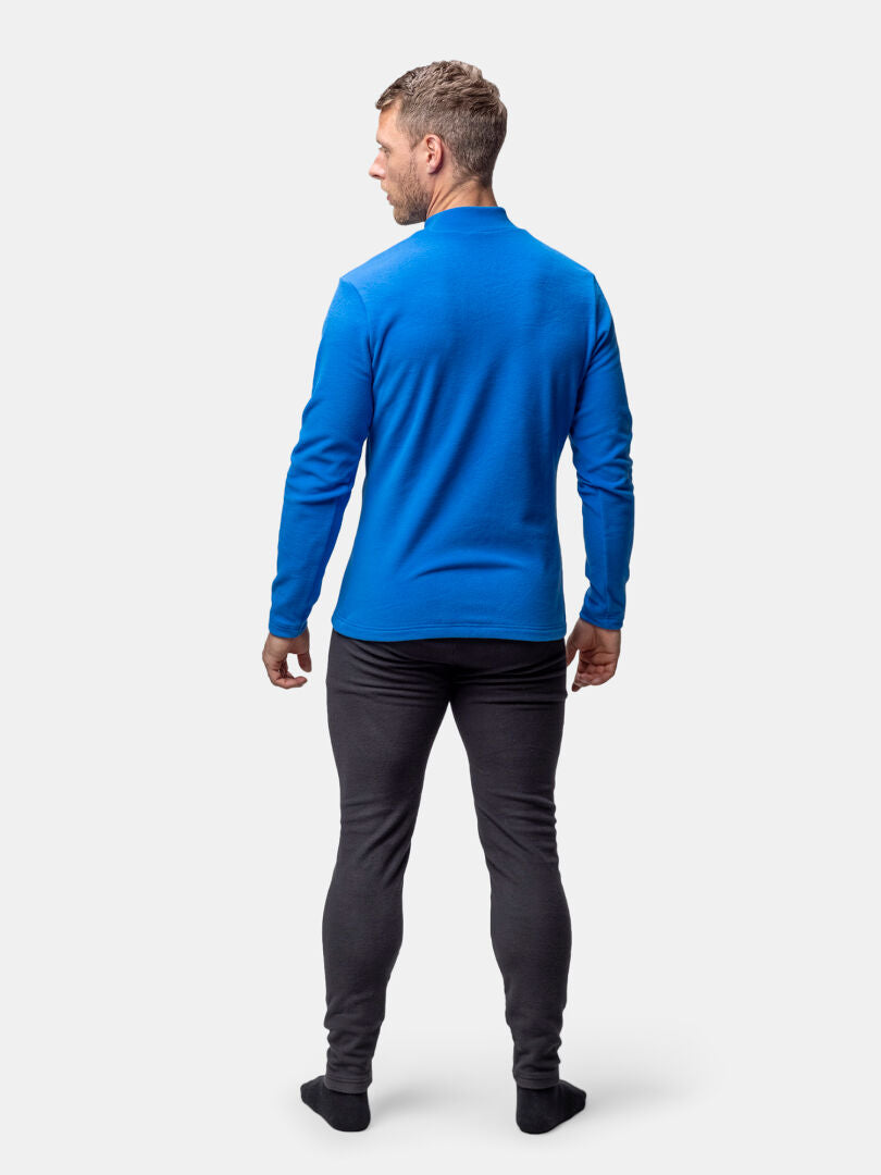 Man med ansiktet vänt bort, klädd i Halti Trone Fleece Tröja Herr, långärmad blå skjorta, svarta byxor, mot vit bakgrund.