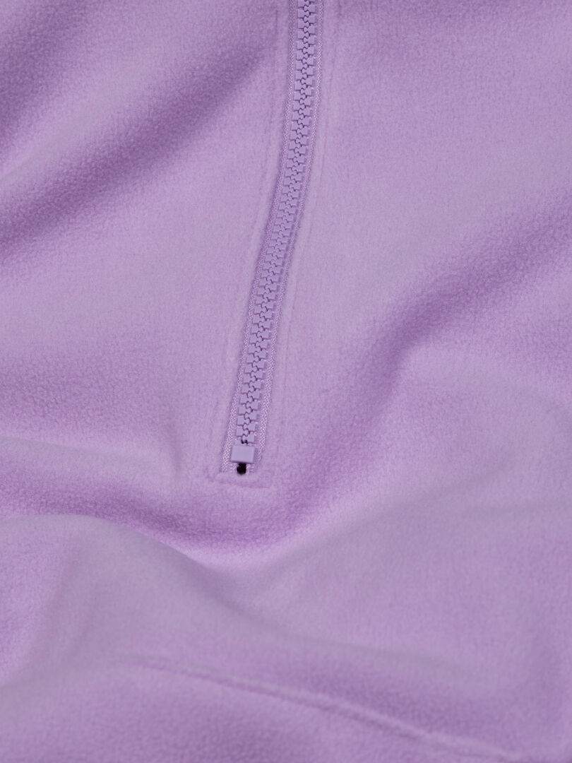 Närbild på Halti Susanne Fleece Hoodie Dam i ljuslila med dragkedjan i mitten delvis öppnad.