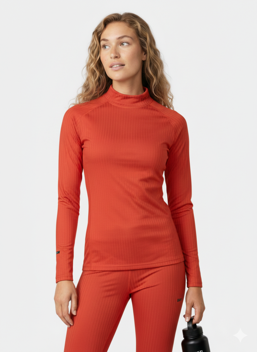 En kvinna i en figurnära Halti Dual Underställ Set Dam för friluftsliv håller i en svart vattenflaska.